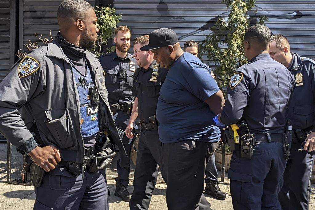 New York City Police Department officers handcuff subway shooting suspect Frank R. James, 62, in the East Village section, of New York, Wednesday, April 13, 2022. James, accused of shooting 10 people on a Brooklyn subway train was arrested Wednesday and charged with a federal terrorism offense after a daylong manhunt and a tipster’s call brought police to him on a Manhattan street.