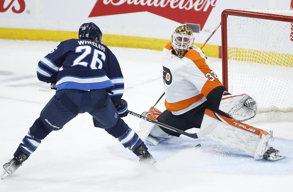 Winnipeg Jets’ Blake Wheeler (26) slides the puck between the legs of Philadelphia Flyers goaltender Felix Sandstrom (32) for the goal during NHL action in Winnipeg on April 27, 2022.