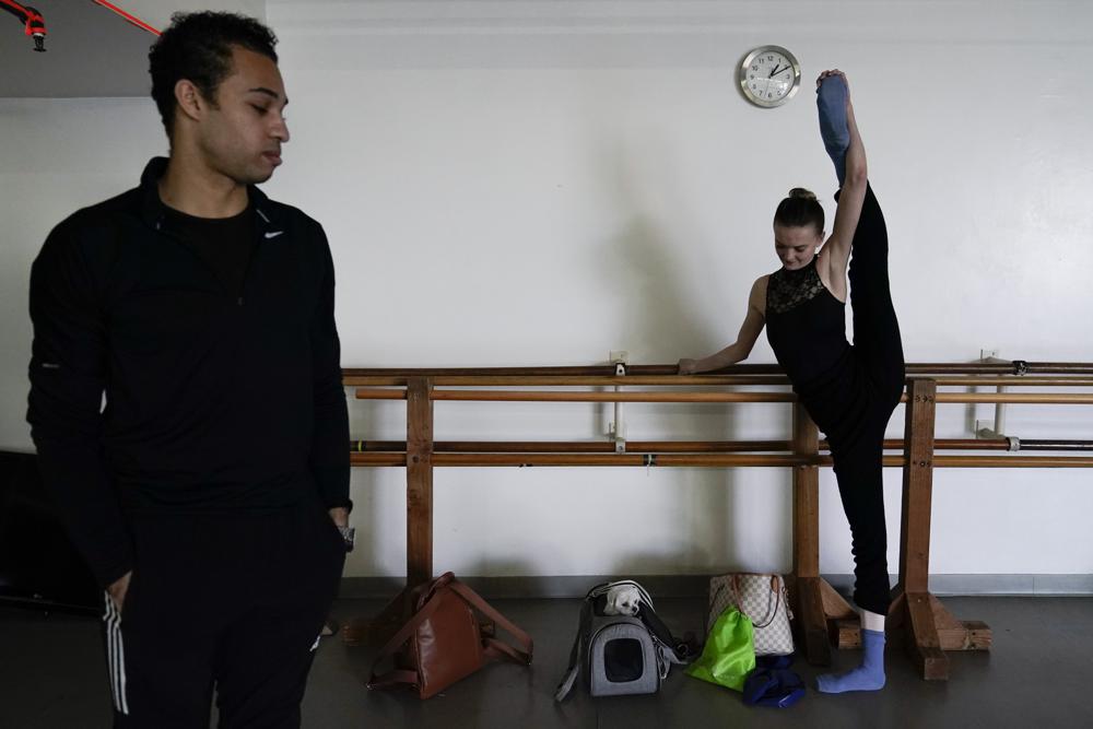 Adrian Blake Mitchell, left, and Andrea Laššáková warm up near their dog, Beau, before rehearsing on Monday, April 18, 2022, in Santa Monica, Calif. (AP Photo/Ashley Landis).