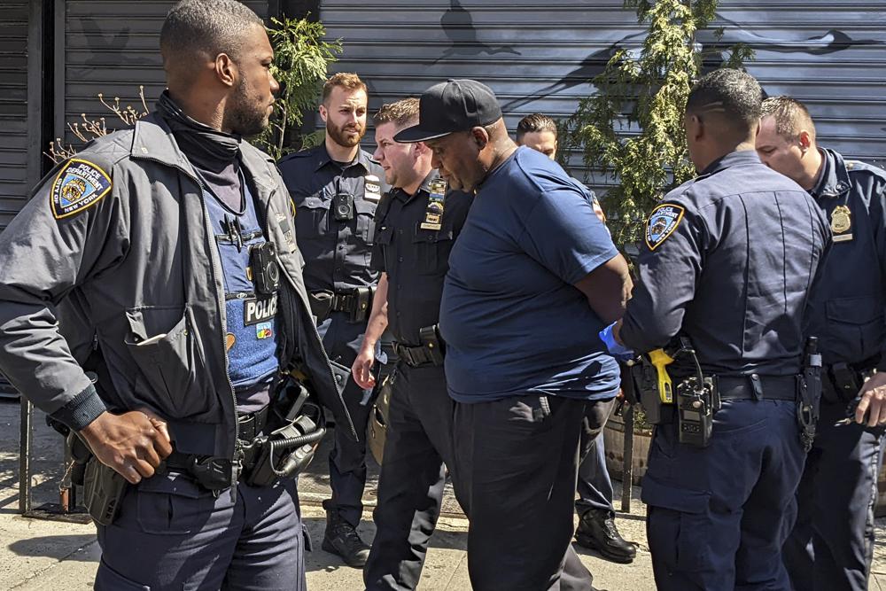 New York City Police Department officers handcuff subway shooting suspect Frank R. James