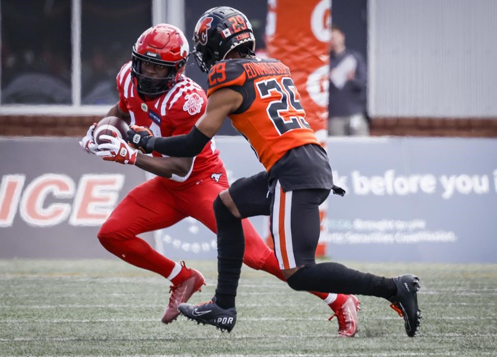 B.C. Lions' Jalon Edwards-Cooper, right, tackles Calgary Stampeders' Shawn Bane during first half CFL pre-season football action in Calgary, Alta., Saturday, May 28, 2022.