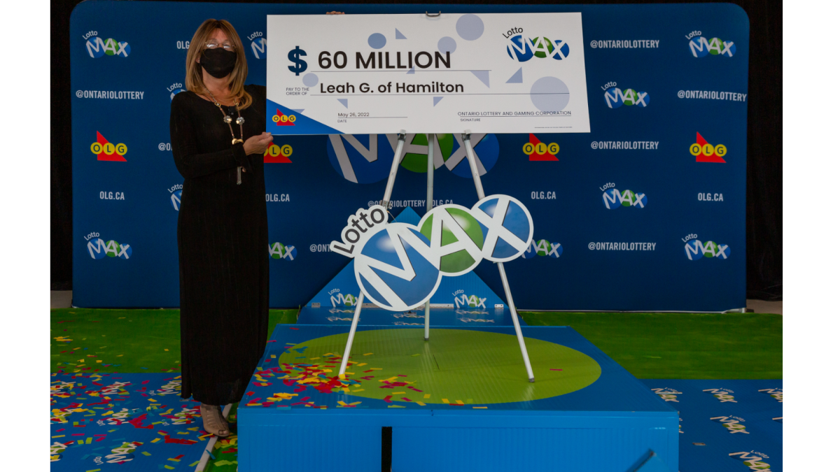 Lotto Max winner Leah Murdoch-Gerics from Hamilton stands beside a large cheque she will soon be able to cash for $60 million. 