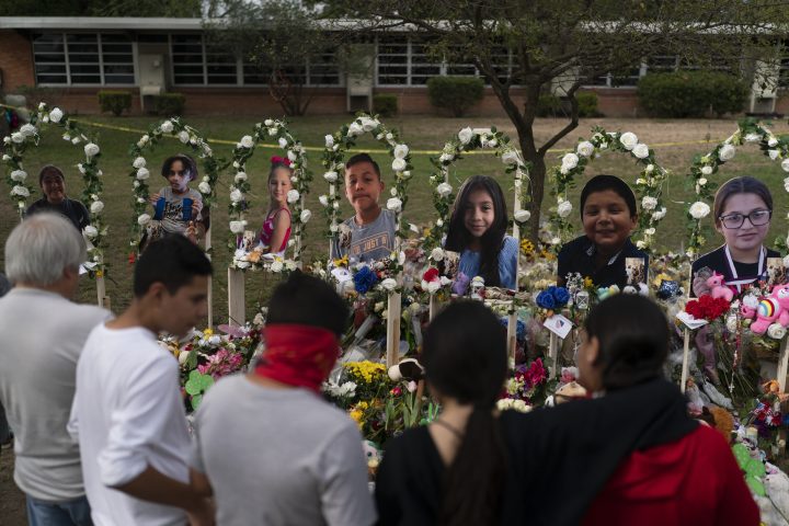 People gather at a memorial at Robb Elementary School in Uvalde, Texas Monday, May 30, 2022, to pay their respects to the victims killed in last week’s school shooting.