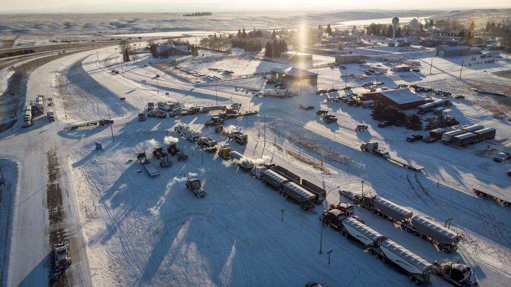 A truck convoy of anti-COVID-19 vaccine mandate demonstrators continue to block the highway at the busy U.S. border crossing in Coutts, Alta., Wednesday, Feb. 2, 2022. Mounties have laid further charges in relation to the Coutts, Alta. border protest earlier this year. THE CANADIAN PRESS/Jeff McIntosh.