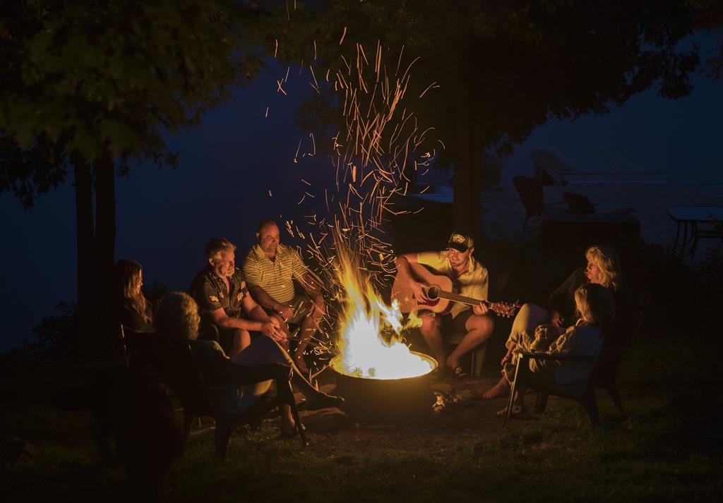  A family enjoys a camp fire by the lake. An open fire ban in forests in the southern half of Quebec was lifted on Monday, July 17, 2023. 