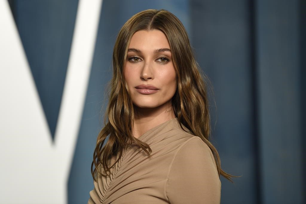 Hailey Bieber in a brown dress arrives at the Vanity Fair Oscar Party on March 27, 2022, at the Wallis Annenberg Center for the Performing Arts in Beverly Hills, Calif.