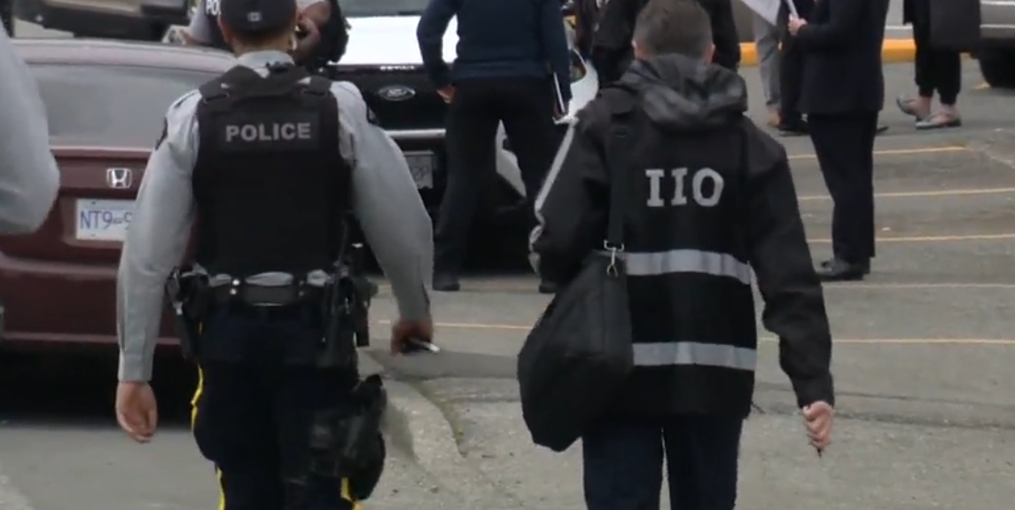 An IIO investigator and an RCMP officer are seen in this undated file photo.