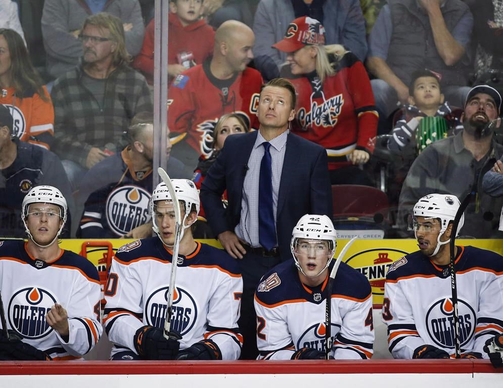 Edmonton Oilers' assistant coach Glen Gulutzan looks to the scoreboard during first period preseason NHL hockey action in Calgary, Monday, Sept. 17, 2018.