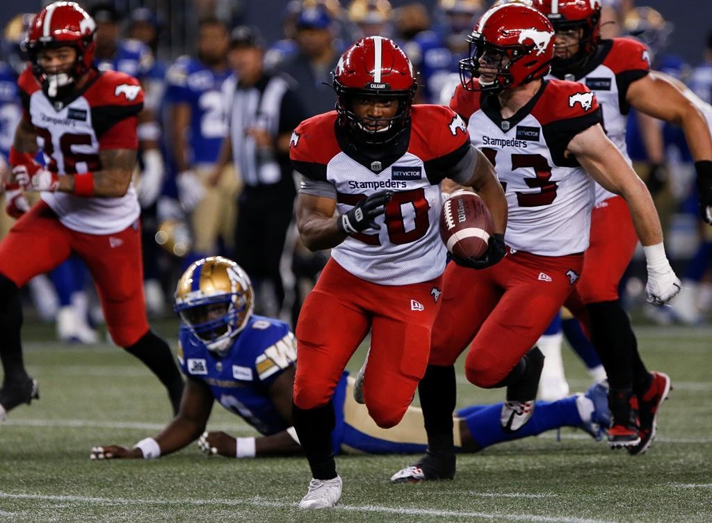 The Calgary Stampeders' Peyton Logan (20) gets the first down against the Winnipeg Blue Bombers during the second half of CFL action in Winnipeg, Friday, July 15, 2022.