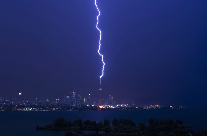 A lightning bolt strikes the CN Tower during a storm in Toronto, early Thursday July 14, 2016. 