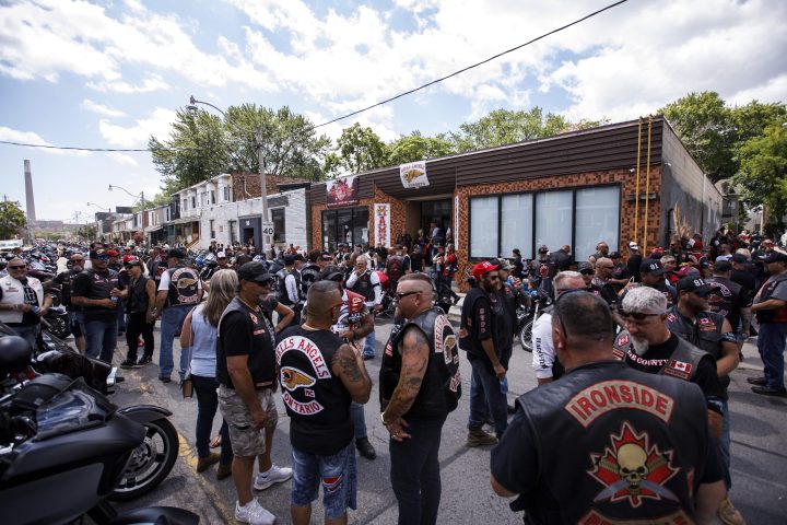A group of bikers gather outside an east-end storefront in Toronto following a procession to honour longtime Toronto Hells Angels member Donny Petersen, who died in late 2021, Thursday, July 21, 2022.