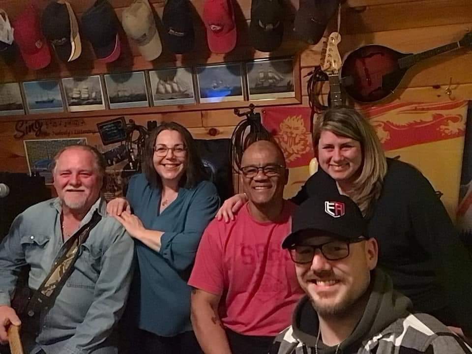 Darrell Richards, middle, sits with members of the band Ryan Drive. Richards, a married father of three, was a bass player with the band.