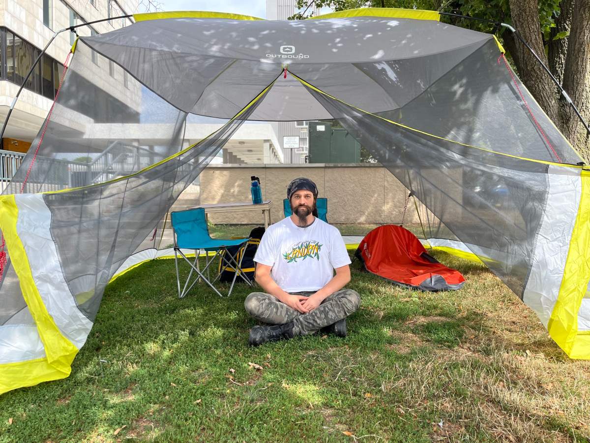 Dan Oudshoorn sits inside a tent near City Hall