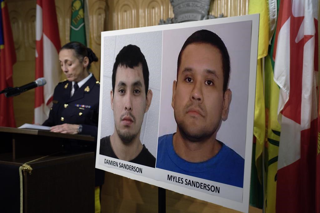 Assistant Commissioner Rhonda Blackmore speaks during a press conference, alongside the mugshots of Damien and Myles Sanderson. THE CANADIAN PRESS/Michael Bell