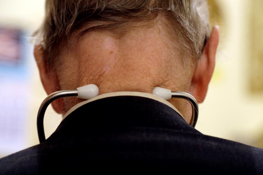 In this Oct. 30, 2012 photo, a doctor wears a stethoscope around his neck as he tends to patients in his office in Illinois. THE CANADIAN PRESS/AP-Jeff Roberson.