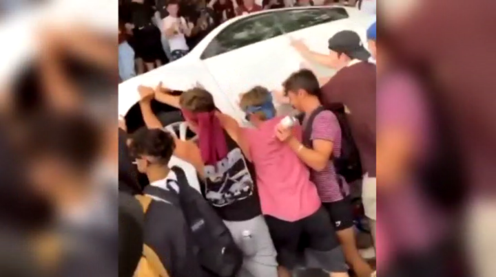 A car being turned over during an unsanctioned homecoming party in Hamilton, Ont. October 2021.