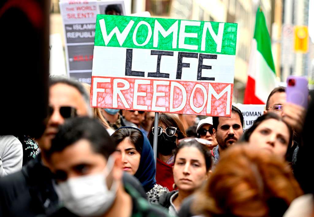 Protestors carry signs reading 'Women Life Freedom.'