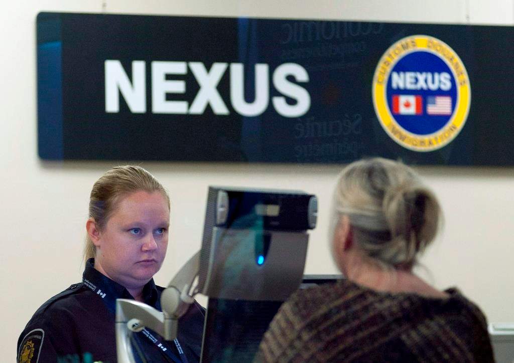 A Canada Border Services Agency officer speaks with a traveller at the Nexus office at the airport in Ottawa.