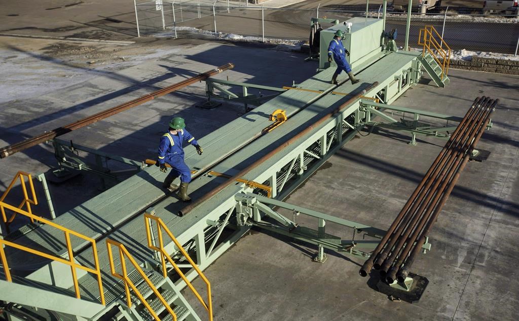 Trainees roll pipe off the catwalk during a training session to lay down drill pipe on a rig floor at Precision Drilling in Nisku, Alta., on January 20, 2016.