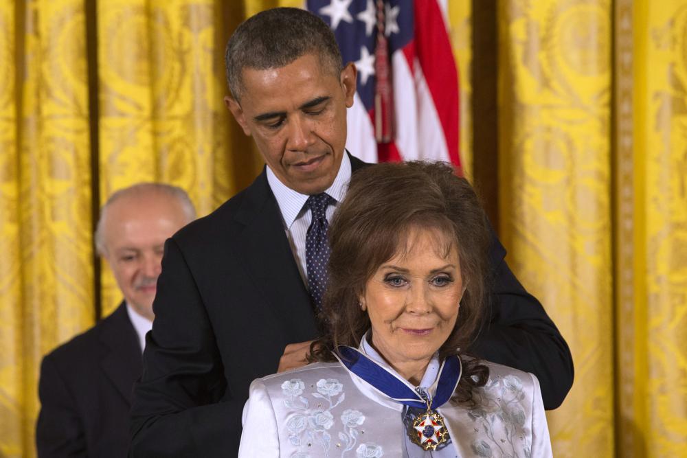 FILE - President Barack Obama awards country music legend Loretta Lynn with the Presidential Medal of Freedom, Wednesday, Nov. 20, 2013, during a ceremony in the East Room of the White House in Washington. Lynn, the Kentucky coal miner’s daughter who became a pillar of country music, died Tuesday at her home in Hurricane Mills, Tenn. She was 90.