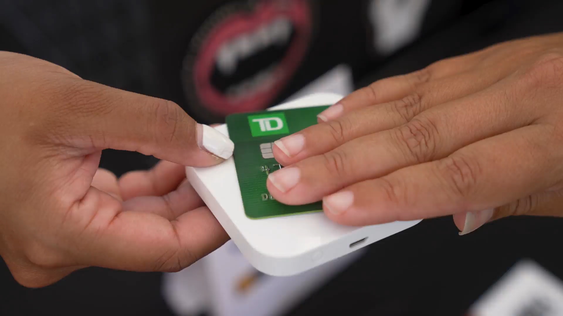 A person is using their debit card to pay for a purchase on a square reader