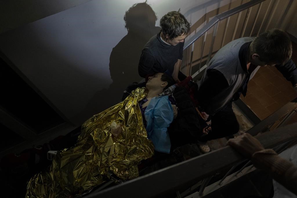 Staff carry 13-year-old Arthur Voblikova on a stretcher up the stairs to the operating room inside a hospital in Kherson, southern Ukraine, Tuesday, Nov. 22, 2022.
