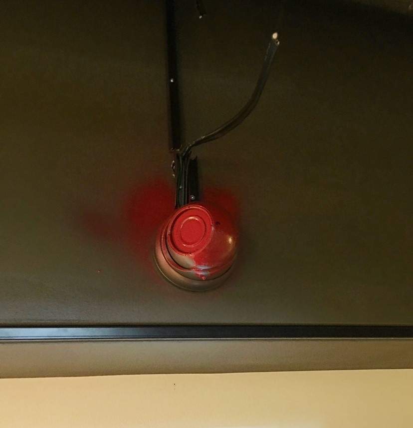 A spray-painted security camera in gallery.
