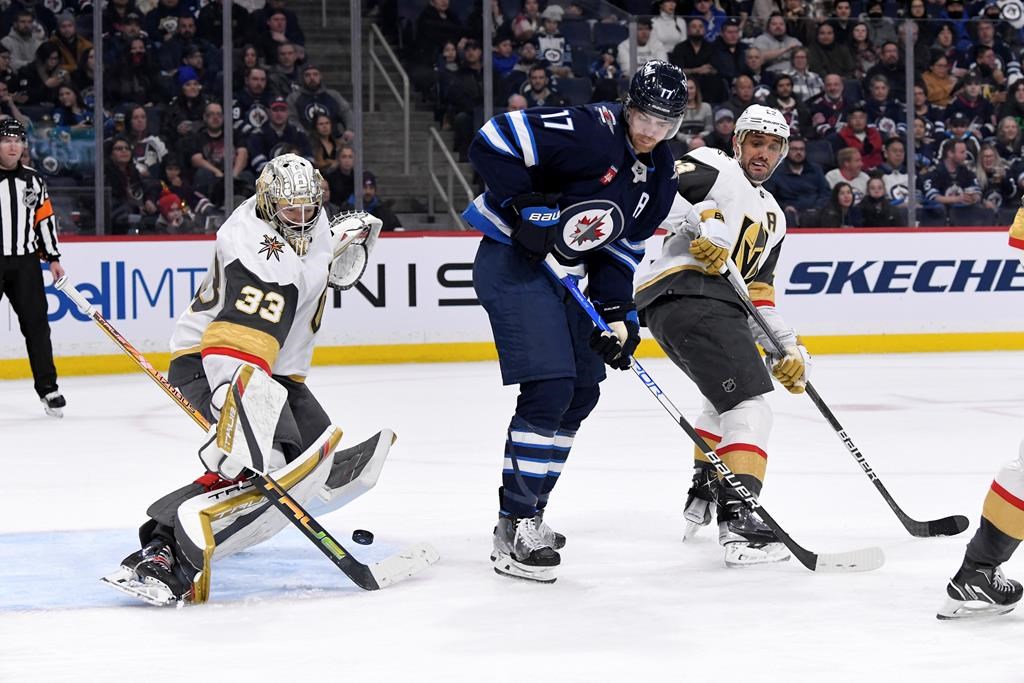 Vegas Golden Knights goaltender Adin Hill (33) makes a save as Winnipeg Jets’ Adam Lowry (17) and Alec Martinez (23) look for the rebound during second period NHL action in Winnipeg on Tuesday December 13, 2022.