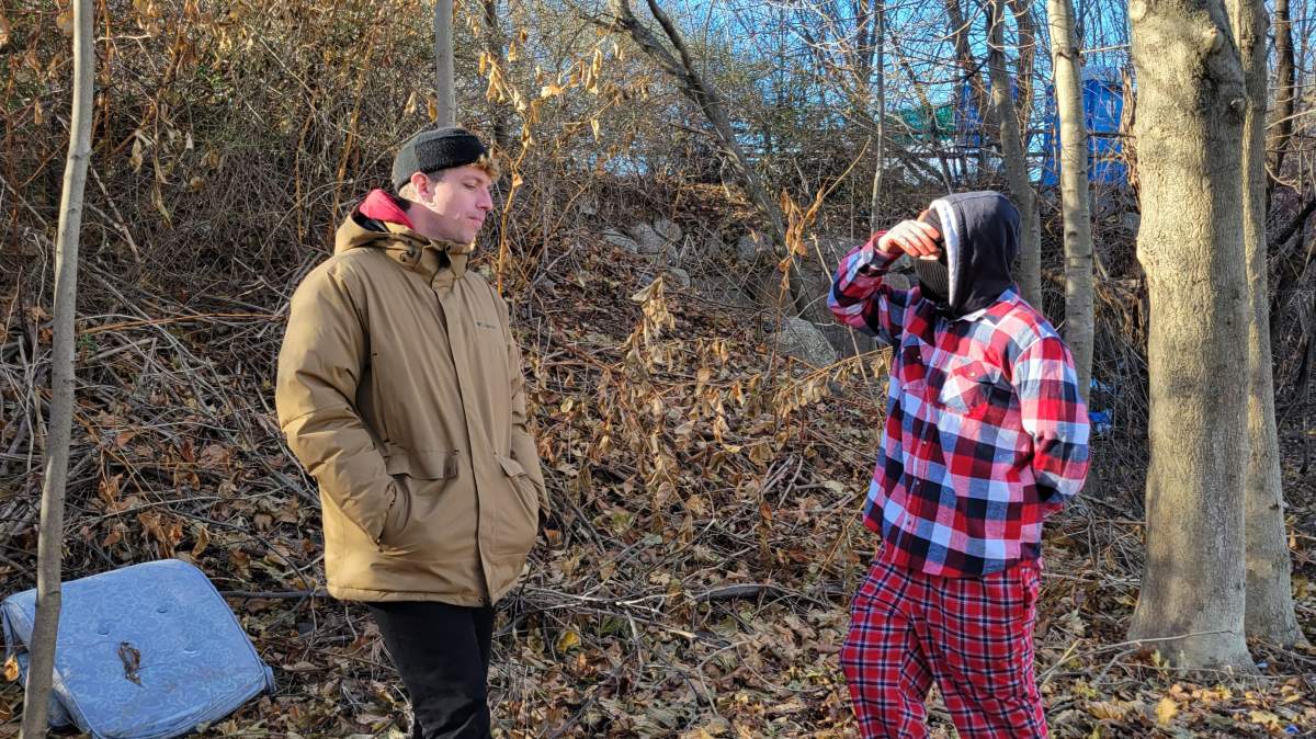 Kyle, an unhoused man living in one of Halifax’s designated tenting sites, speaks with Nathan Doucet, an outreach worker with Out of the Cold.