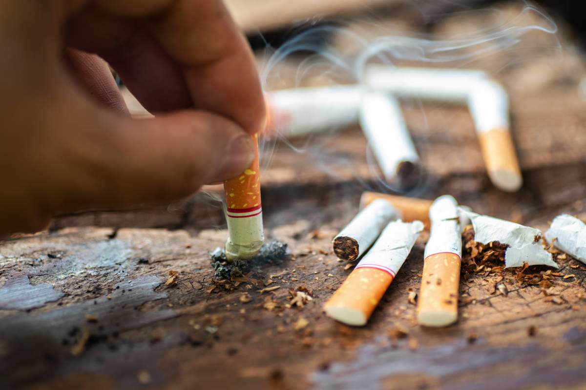 File - person puts out a lit cigarette.