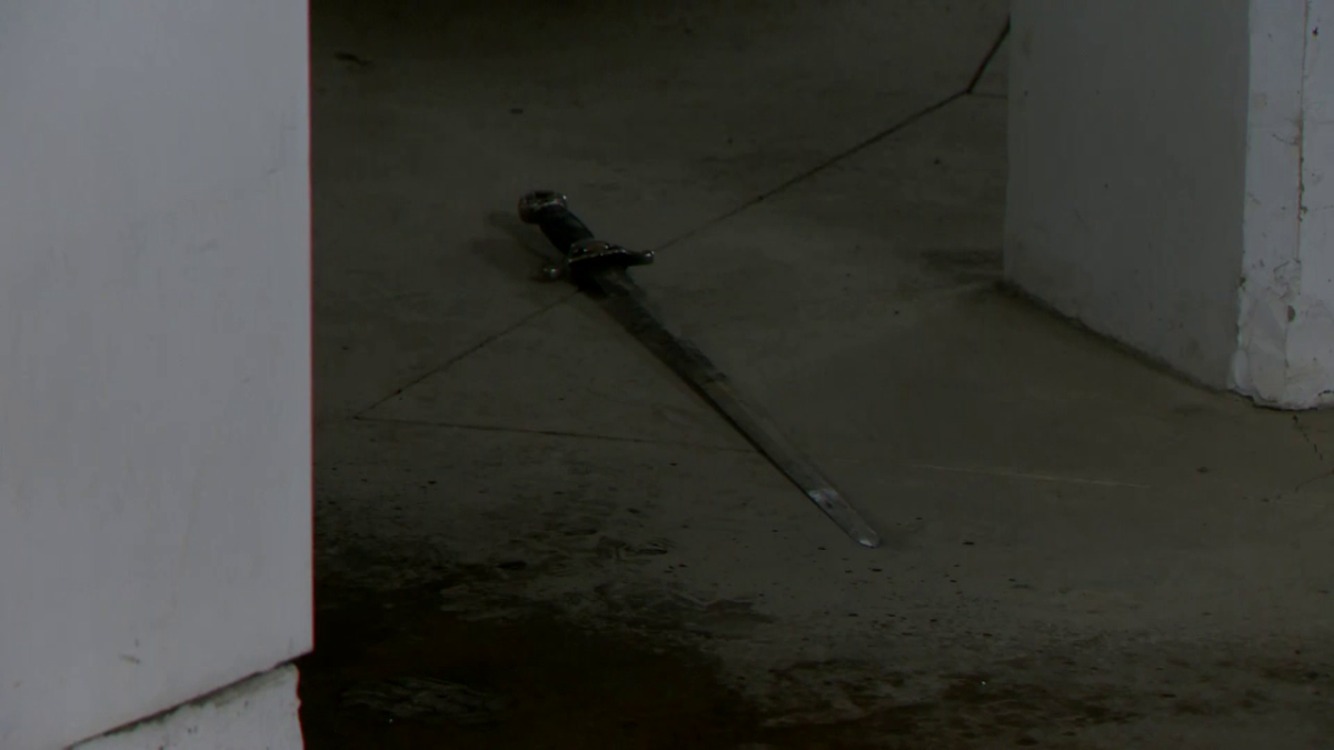 Calgary police say ASIRT is investigating after an officer-involved shooting at a N.W. parkade on Dec. 22, 2022. A Global News videographer observed what appeared to be a sword on the ground behind police tape.