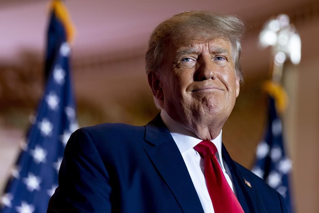 Donald Trump. He is wearing a blue suit jacket and a red tie.