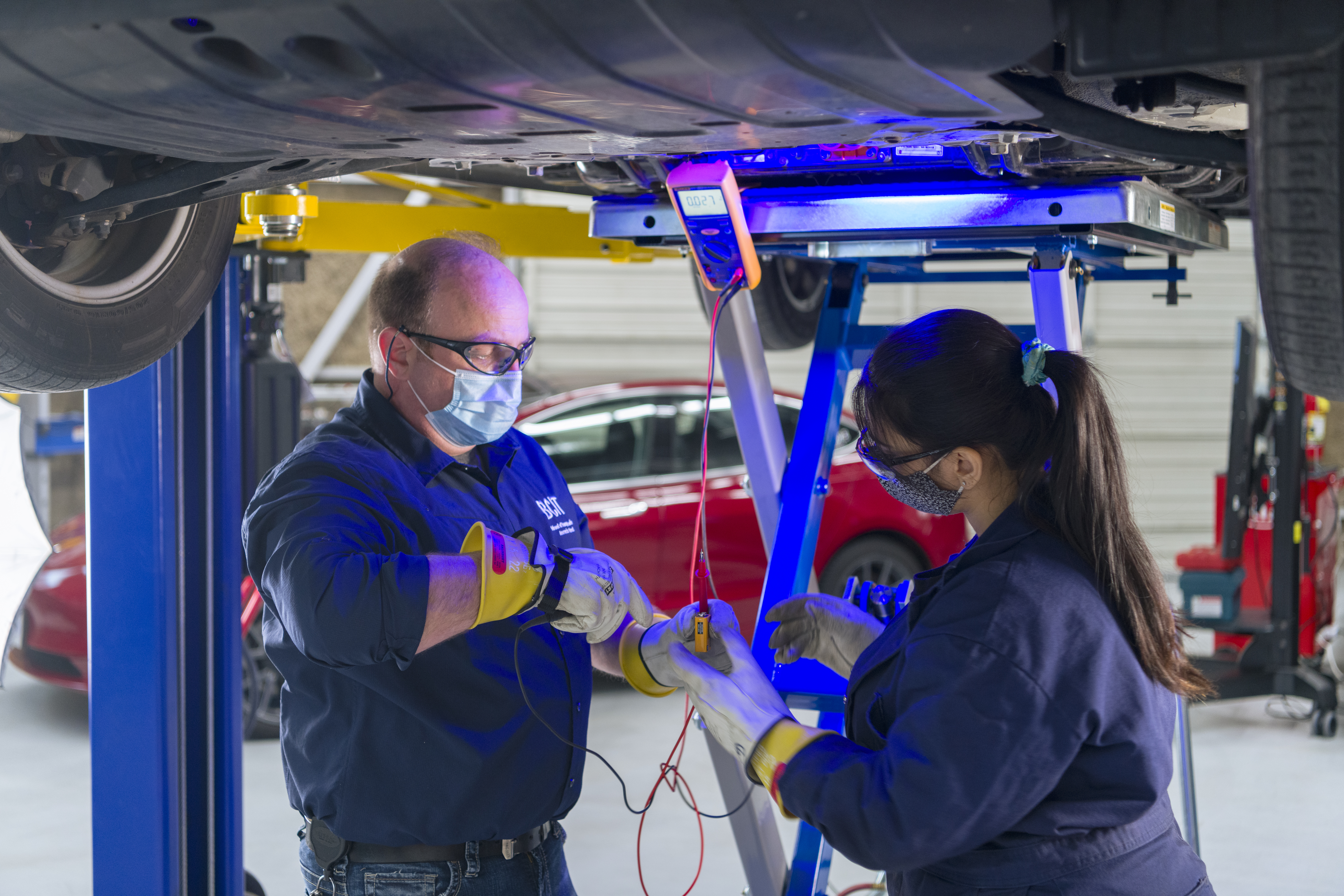 Instructor Jim Berladyn helps a student with a 'live-dead-live' test. It's to ensure no charge is coming out of the EV battery before it's removed for servicing.