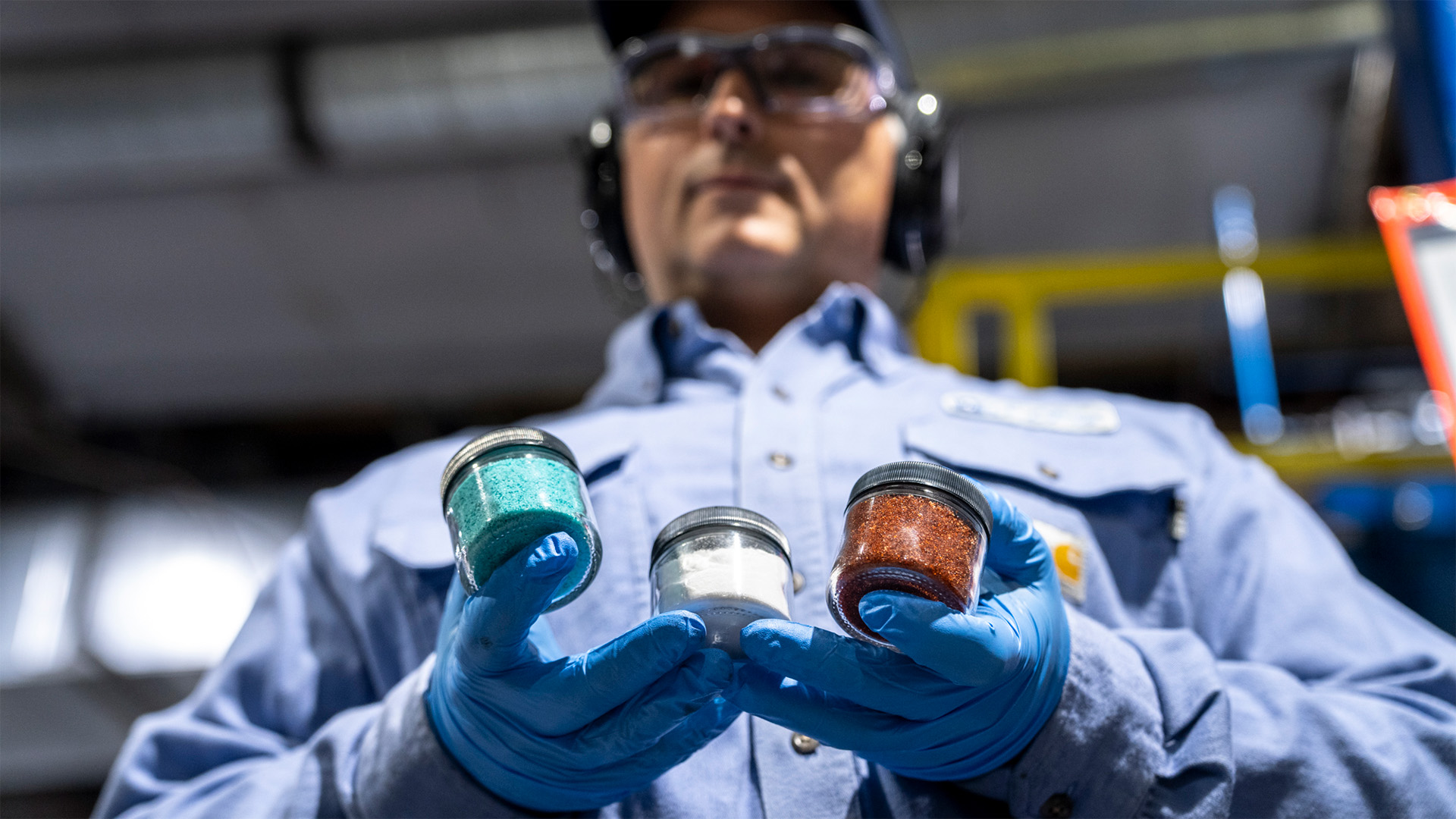 Li-Cycle plant manager, Daniel Demers, holds nickel sulfate, lithium carbonate, and cobalt sulfate.