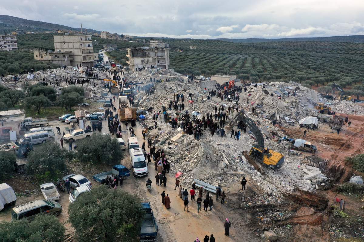 Aid workers search the rubble in a Syrian town hit by the 7.8 magnitude earthquake that hit Turkey as well.