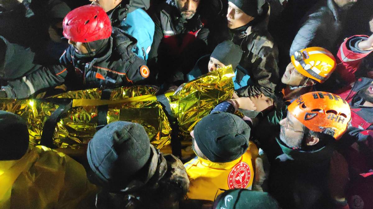 Rescue workers in Turkey carry out a young woman from rubble.