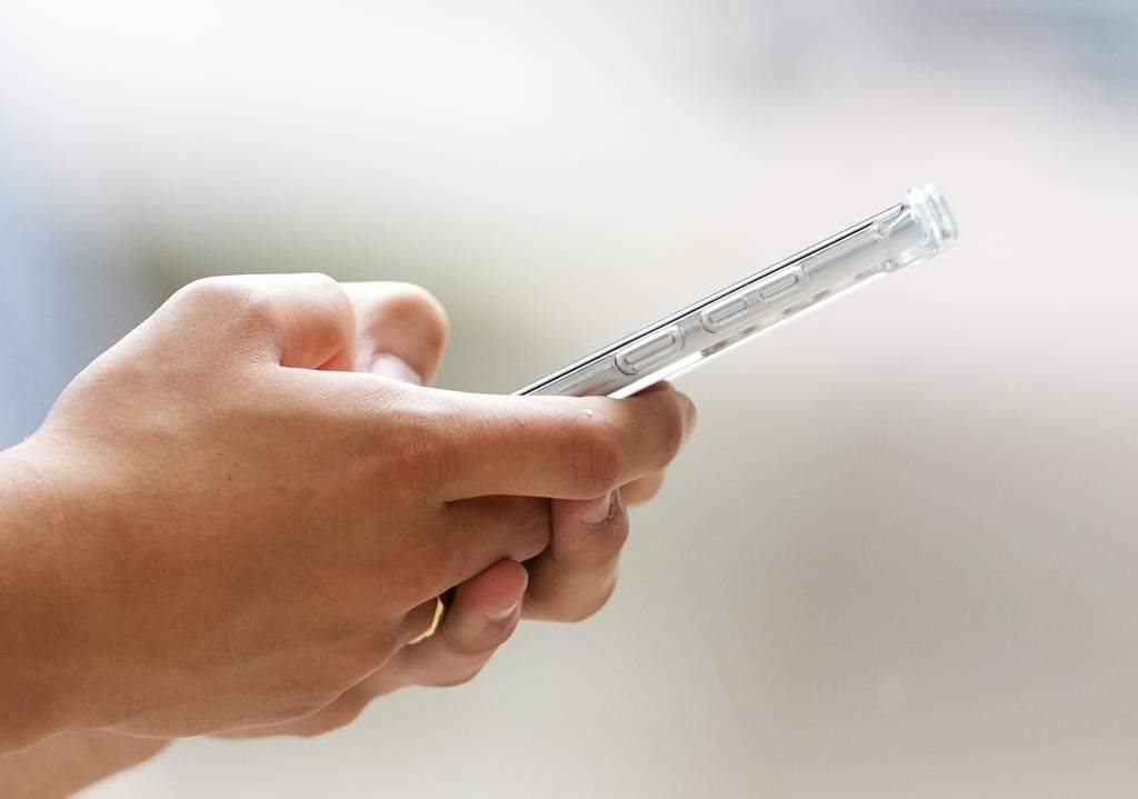 FILE A person uses a cellphone in Ottawa on Monday, July 18, 2022.  