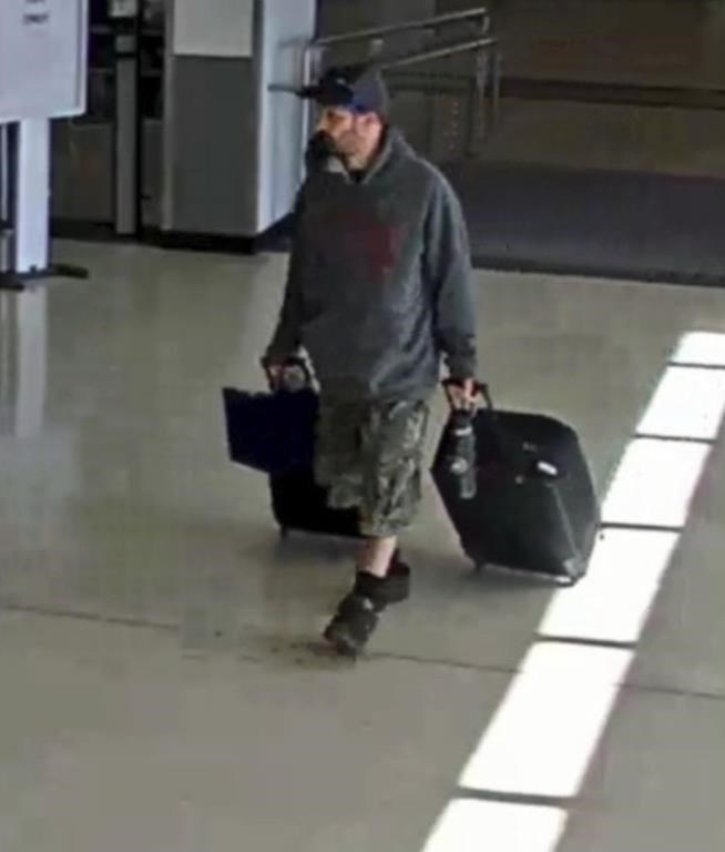 Marc Muffley holding two suitcases.