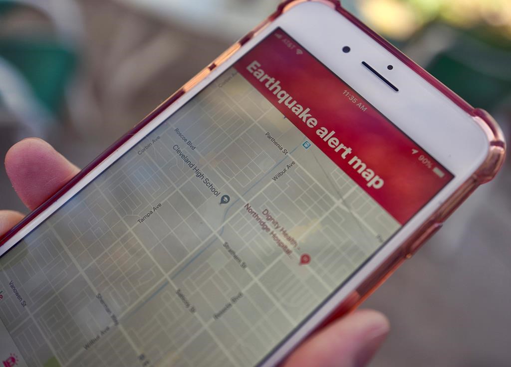 A mobile phone customer looks at an earthquake warning application on their phone in Los Angeles, Thursday, Jan. 3, 2019. Two separate minor earthquakes were reported off the coast of British Columbia overnight. THE CANADIAN PRESS/AP-Richard Vogel.