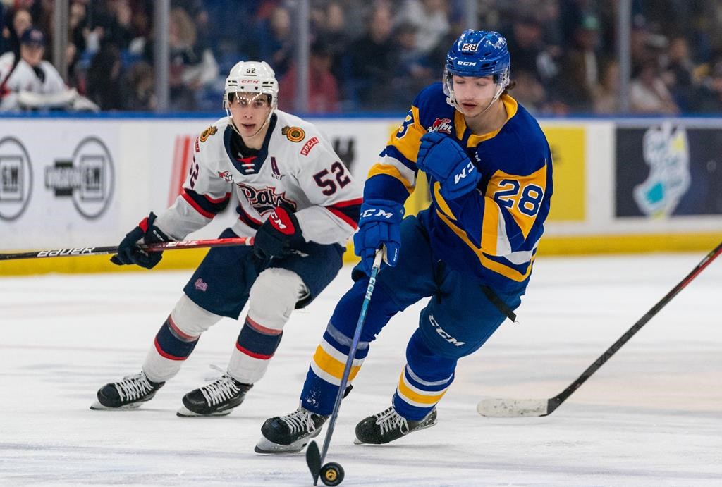 Saskatoon Blades forward Lukas Hansen (28) skates with the puck during the third period of WHL playoff hockey action against Regina Pats in Saskatoon, Sask., on Friday, March 31, 2023. THE CANADIAN PRESS/Heywood Yu.