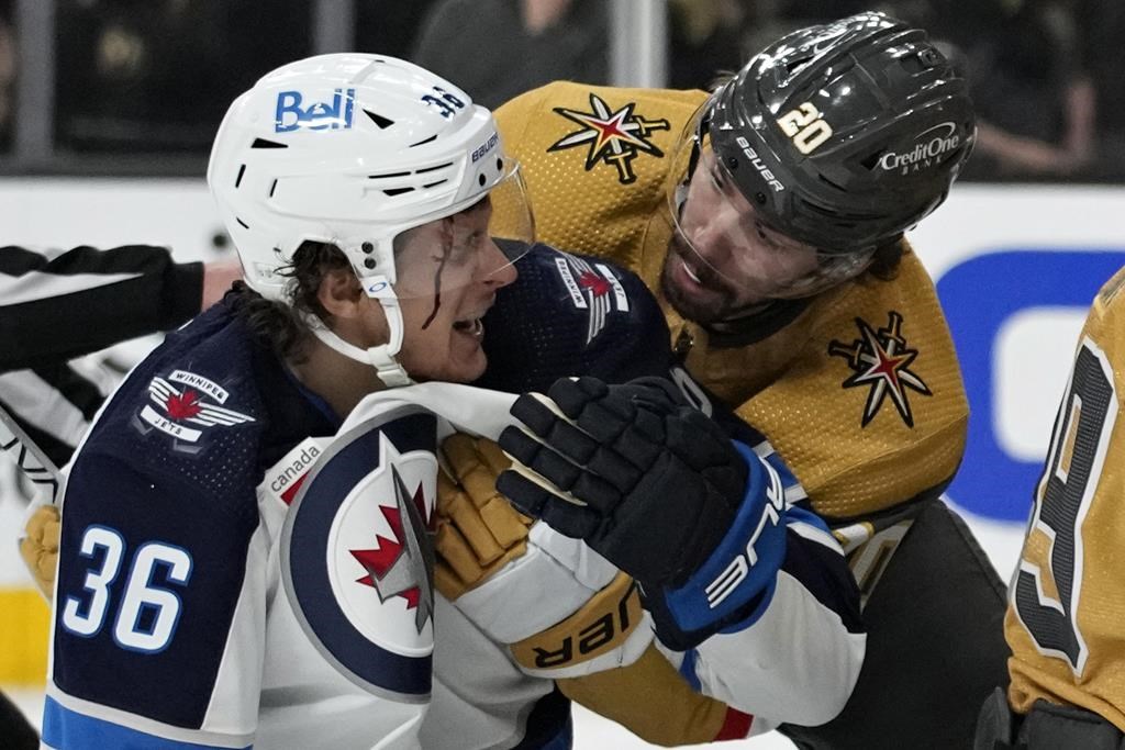 Vegas Golden Knights centre Chandler Stephenson (20) helps Winnipeg Jets center Morgan Barron (36) after Barron cut his face on a skate during the first period of Game 1 of an NHL hockey Stanley Cup first-round playoff series on April 18 in Las Vegas. (AP Photo/John Locher)