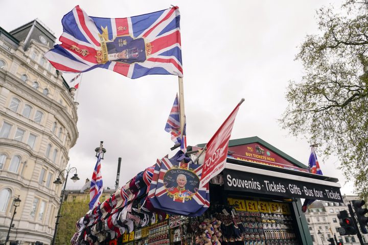 King Charles coronation memorabilia, many including Union Jack flags, on display at an outdoor stand