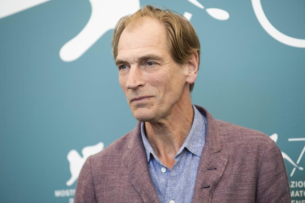 FILE - Actor Julian Sands poses for photographers at the Venice Film Festival in Venice, Italy, on Sept. 3, 2019.