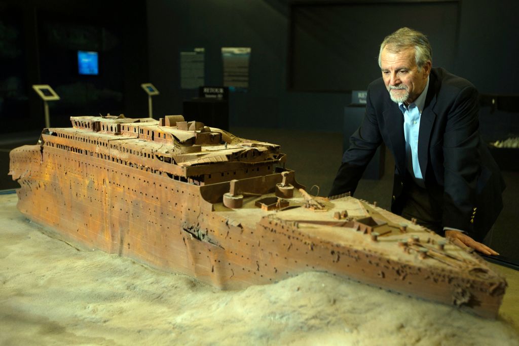 Paul-Henri Nargeolet, director of a deep ocean research project dedicated to the Titanic, poses next to a miniature version of the sunken ship inside a new exhibition, at 'Paris Expo', on May 31, 2013, in Paris.