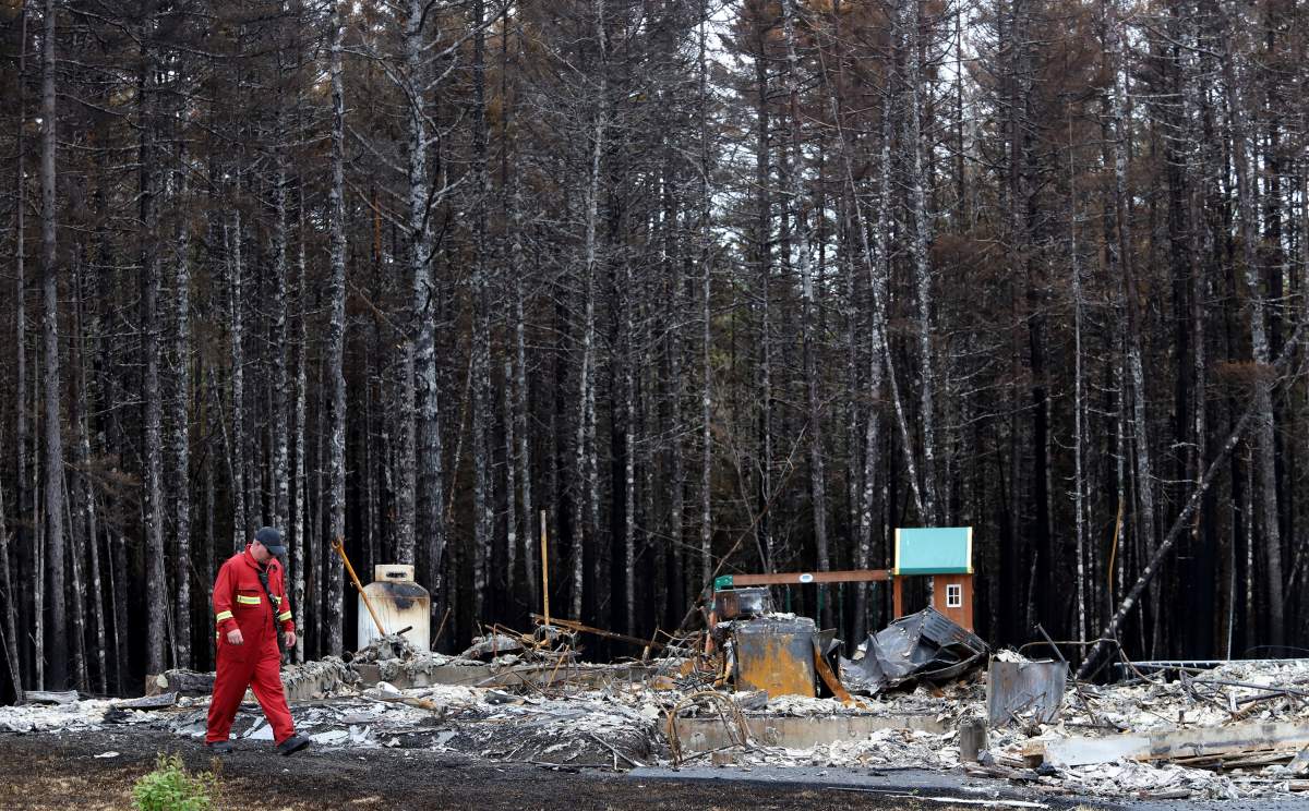 Halifax regional firefighter, Adrian Sweet walks near a destroyed home with an intact playset on Bonsai Drive following a wildfire in Hammonds Plains, N.S. Tuesday June 6, 2023.