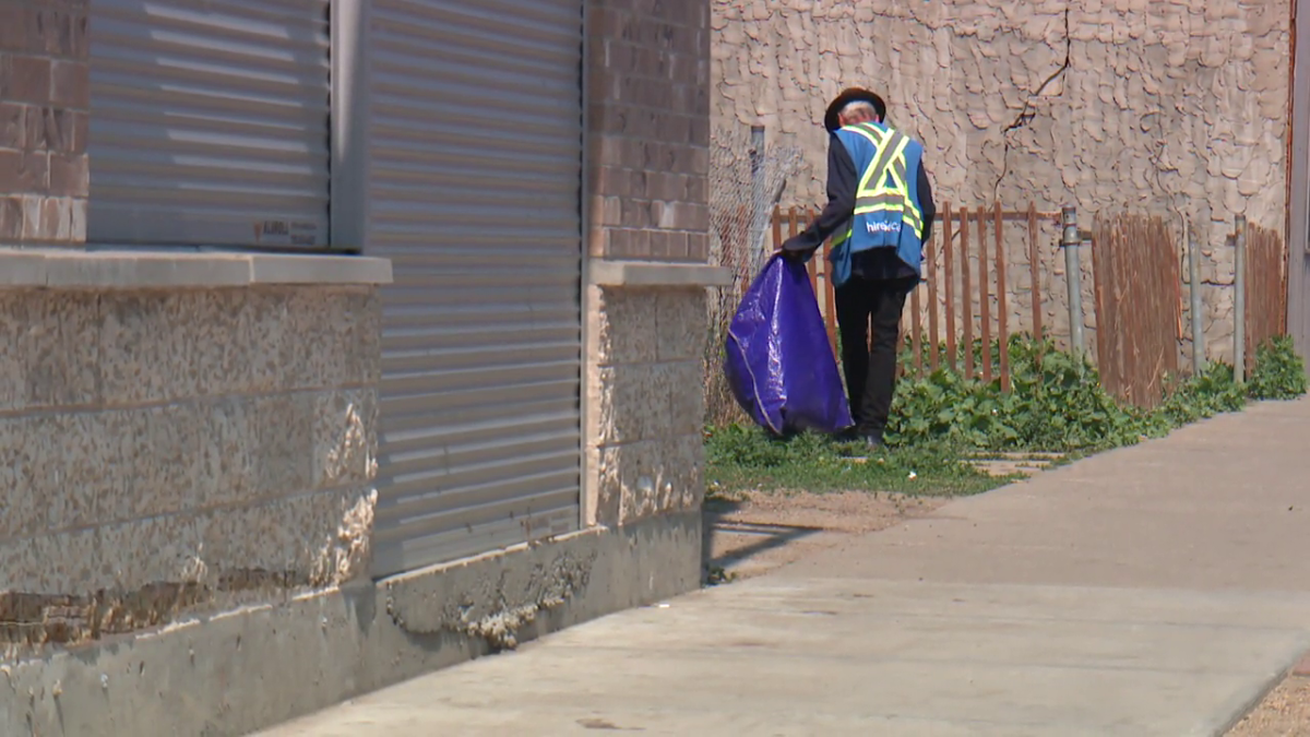 A man cleans up garbage in Edmonton’s Chinatown.