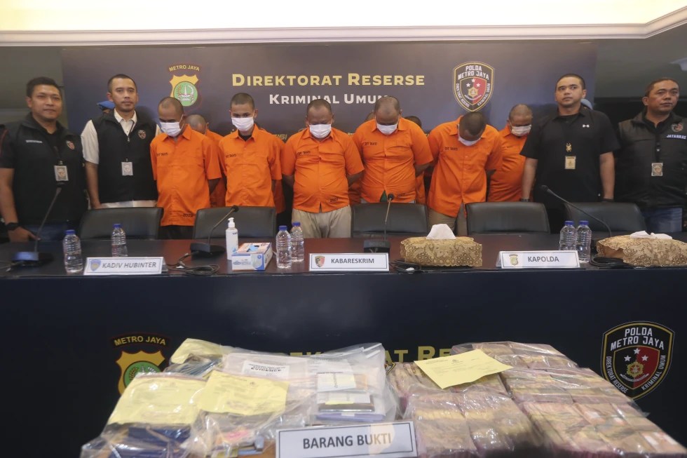 Indonesian police officers escort suspects and display the items of evidence during a press conference at Jakarta police headquarters in Jakarta, Indonesia, Thursday, July 20, 2023. Indonesian police are investigating an illegal trade in human organs involving a police and an immigration officers who were accused of helping traffickers send 122 Indonesians to a hospital in Cambodia to sell their kidneys, police said.