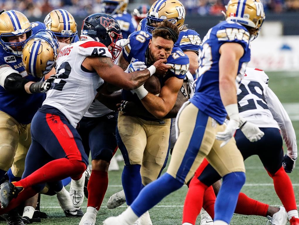 Montreal Alouettes’ Tyrell Richards (42) hits Winnipeg Blue Bombers’ Brady Oliveira (20) as he runs with no helmet during first half CFL action in Winnipeg Thursday, August 24, 2023. THE CANADIAN PRESS/John Woods