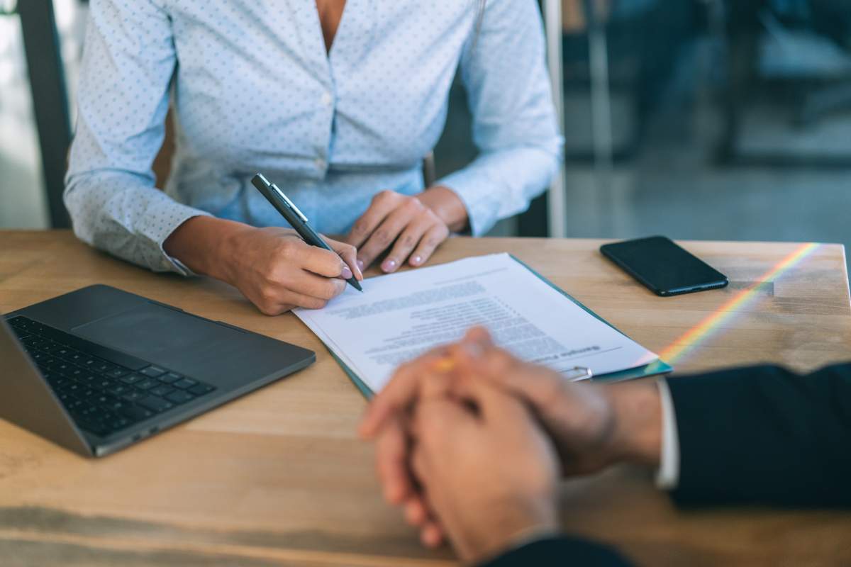 Unrecognizable business people signing a contract after successful agreement