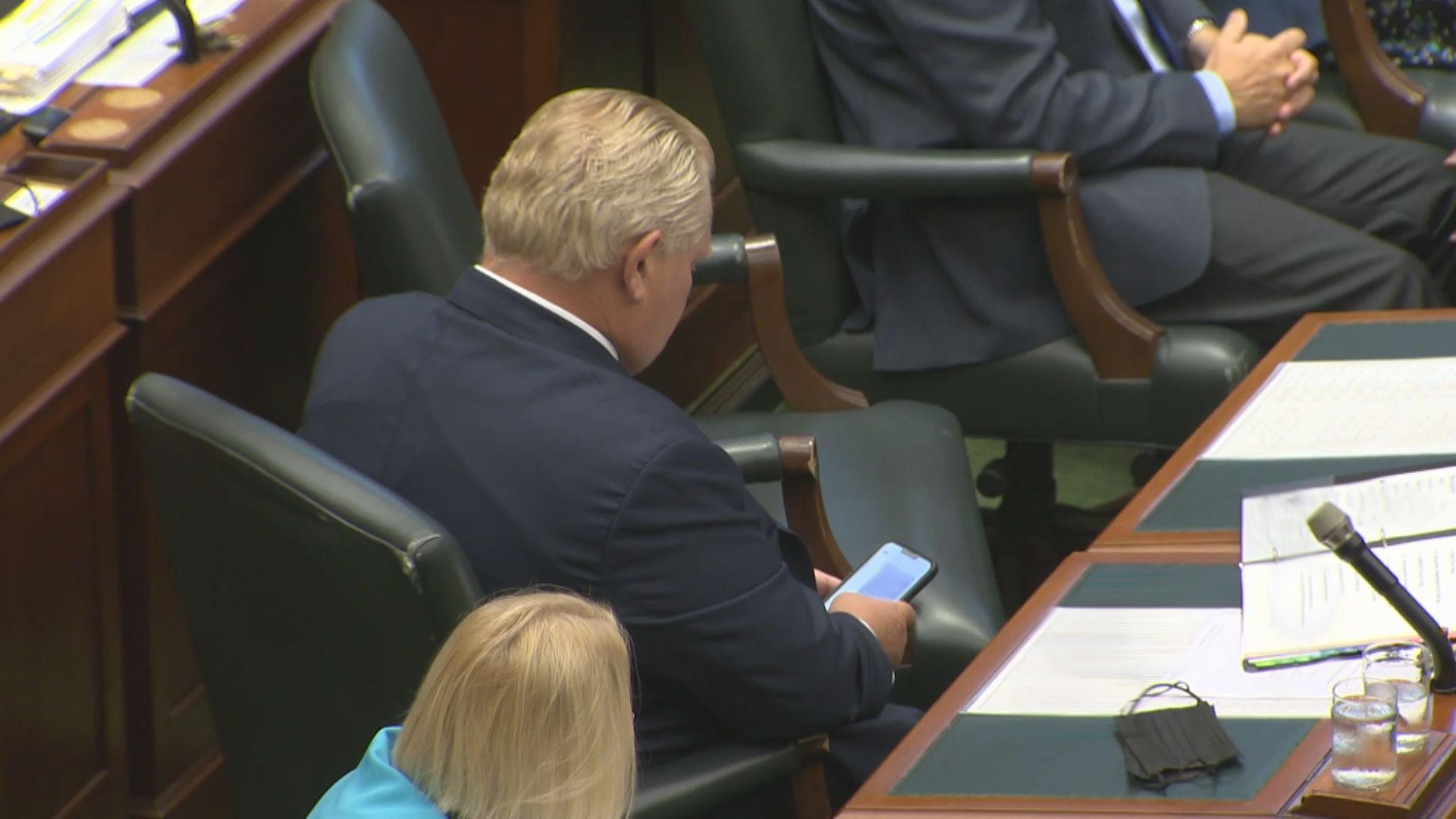 Ontario Premier Doug Ford looks at his cellphone inside the legislature.